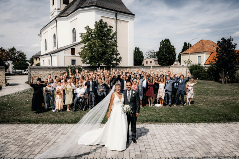 Traditionelles Gruppenfoto – Das Brautpaar mit Familie und Freunden in Trausdorf